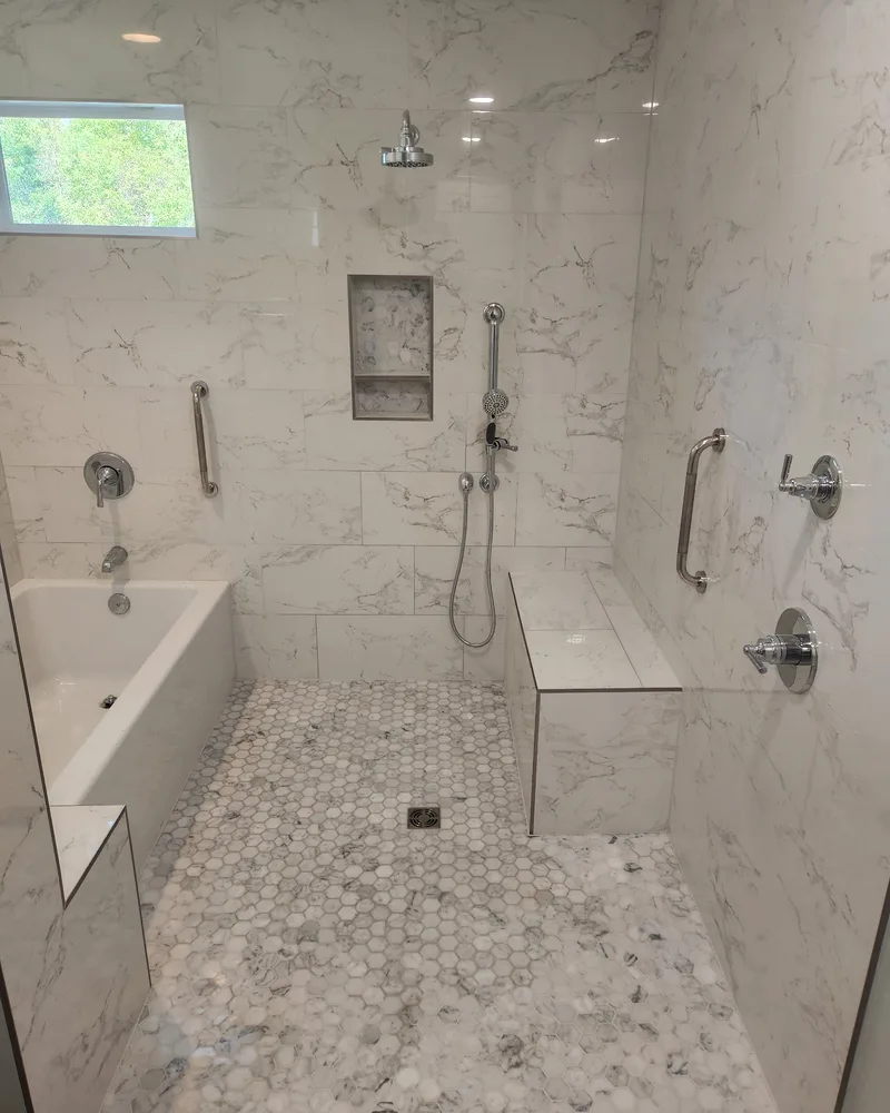 Accessible tile shower with grab bars, a built-in bench and a hexagon mosaic floor