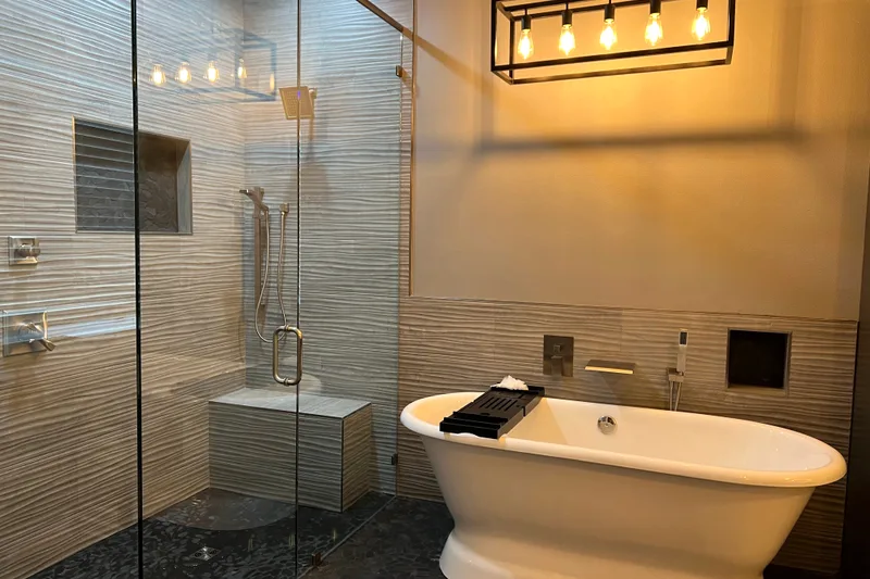 Bathroom remodeling in Baton Rouge: a freestanding tub, a glass shower and textured stone tile walls