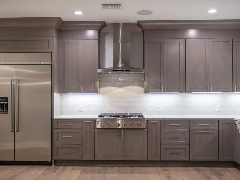 Kitchen renovation with gray shaker cabinets, a stainless hood and a built-in refrigerator