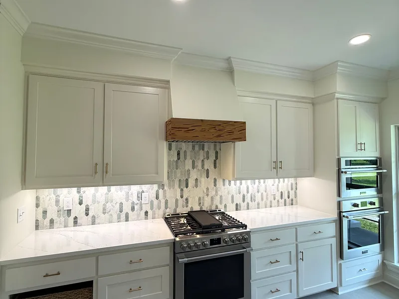 Range wall with a reclaimed wood hood beam and a mosaic tile backsplash