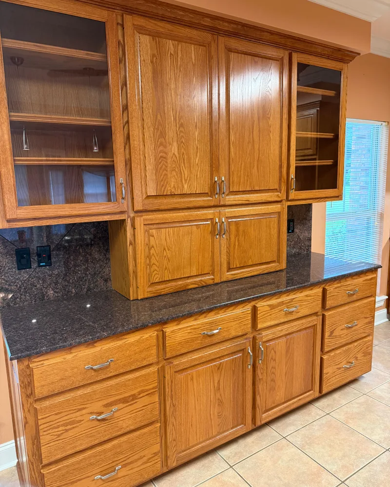Kitchen remodel, before: an oak hutch with glass doors over dark granite counters