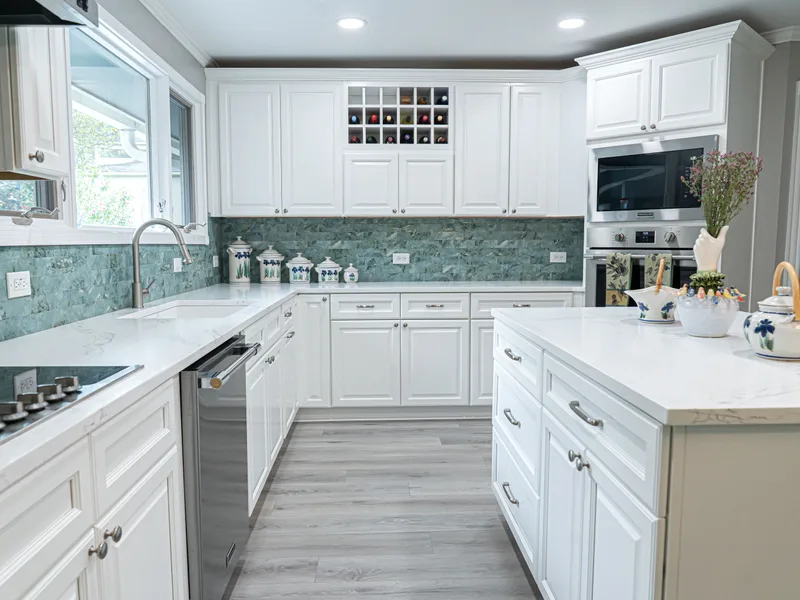 Kitchen remodel in Baton Rouge with a long quartz island and a teal glass tile backsplash
