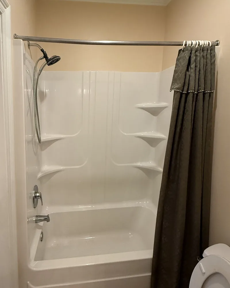Tub and shower before the remodel Tub and shower remodel, before: a white fiberglass tub-shower insert with a shower curtain
