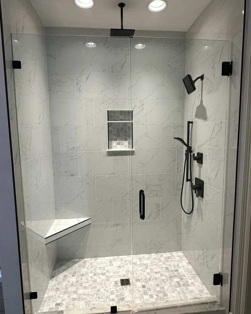 Tub-to-Shower Conversion in Baton Rouge: What to Know Before You Remodel Walk-in shower in a Baton Rouge bathroom remodel: frameless glass, a rain head, a recessed niche, a built-in bench and a pebble tile floor