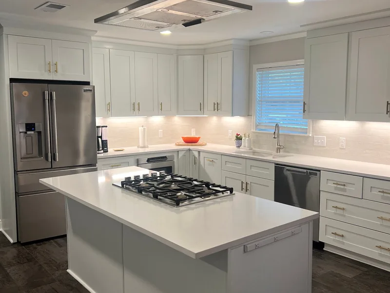 White kitchen with a large quartz island and a gas cooktop